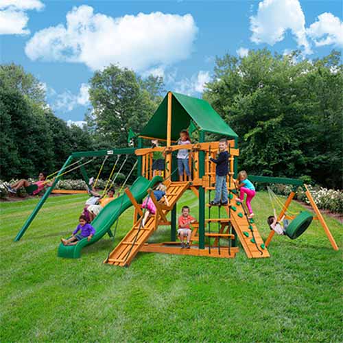 Gorilla Playsets Frontier后院秋千和攀岩设置在阳光明媚的花园的草坪上。